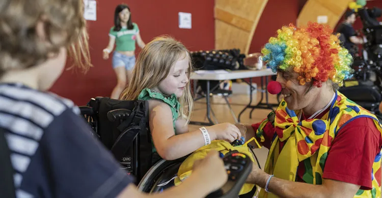 Un clown avec une petite fille sur un fauteuil lors de la Journée des familles à Epinal