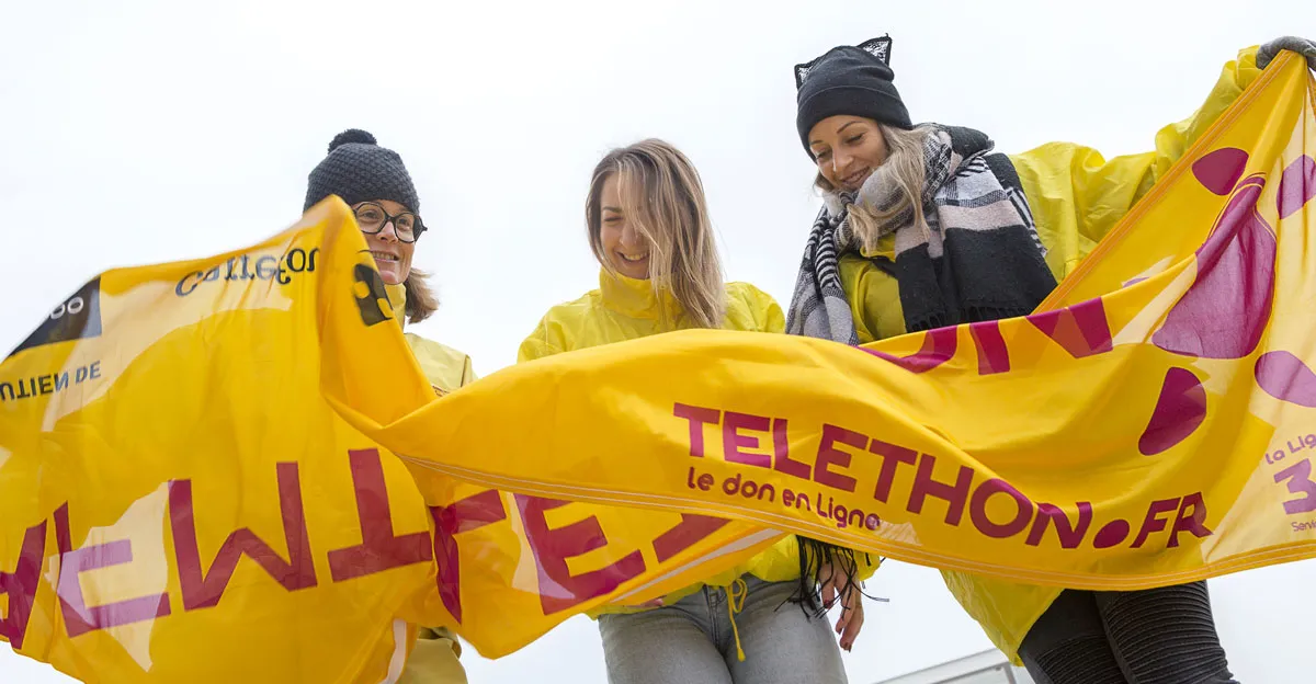 des bénévoles tenant une banderole téléthon