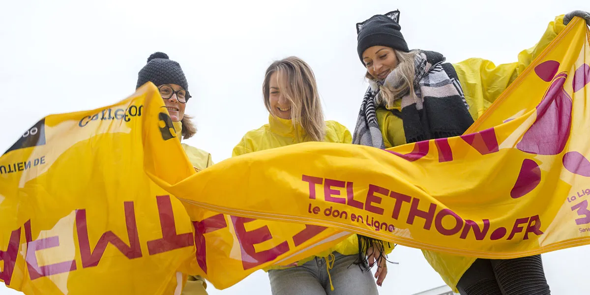 bénévoles tenant une banderole téléthon