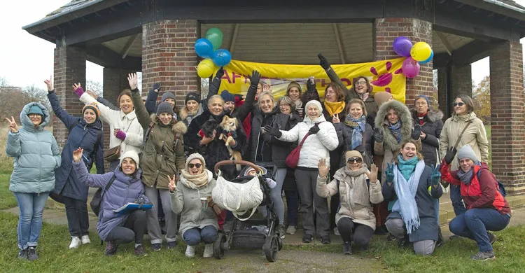 Les bénévoles londoniens posent devant la banderole Téléthon après la marche solidaire